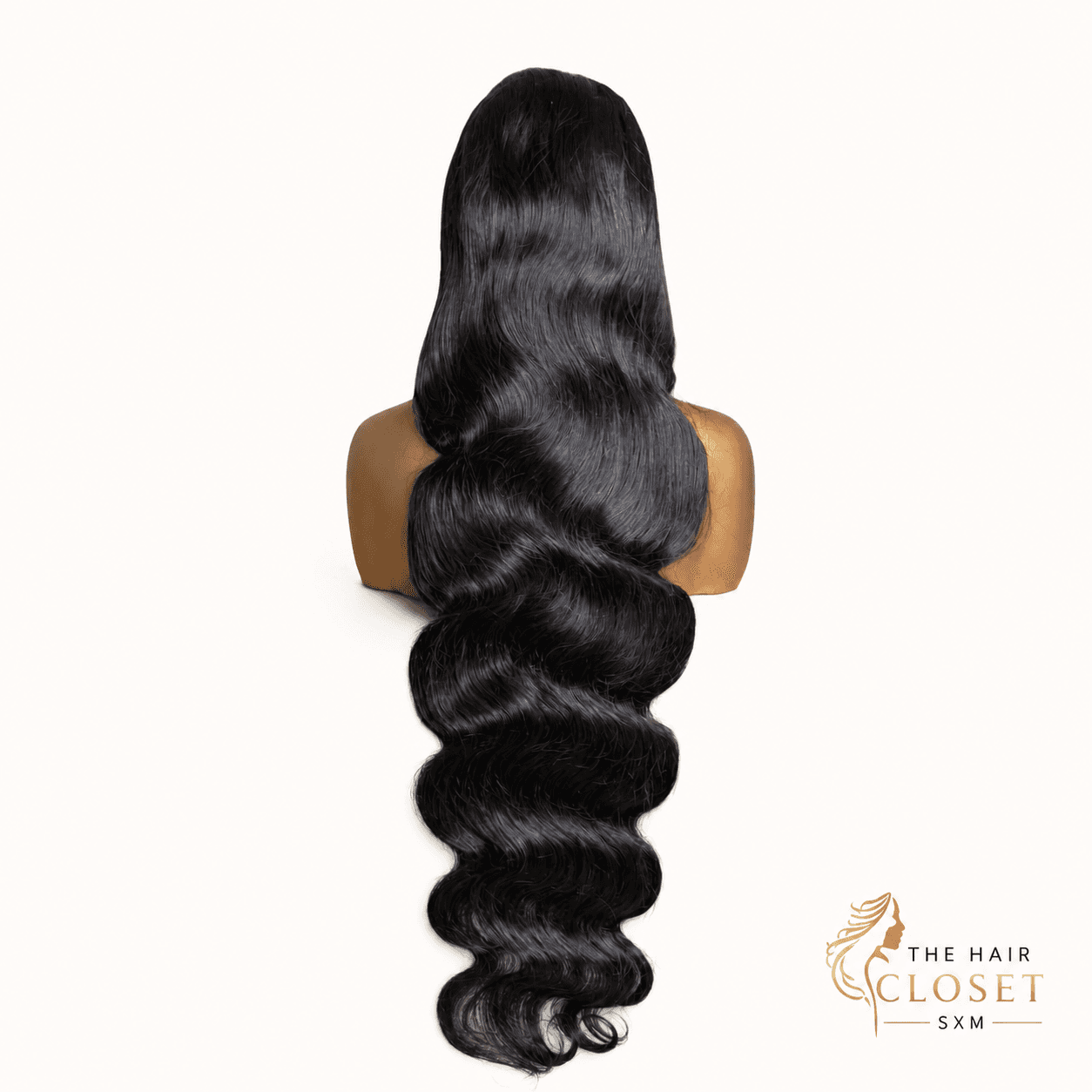 Full dark body-wave wig on a clean cream background